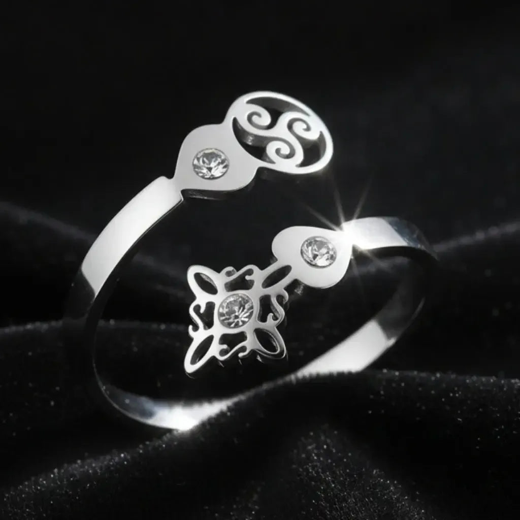 Close-up of silver Triskele Triple Spiral open ring with Celtic witch knot charm and sparkling zircon stones