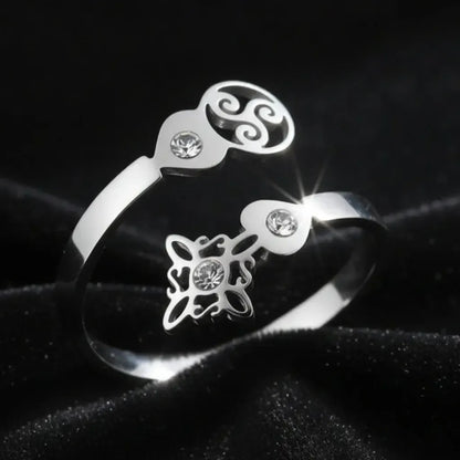 Close-up of silver Triskele Triple Spiral open ring with Celtic witch knot charm and sparkling zircon stones