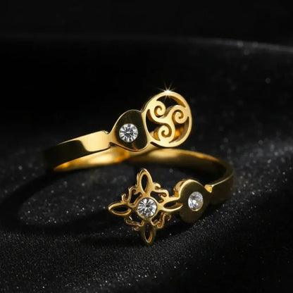Gold Triskele Triple Spiral open ring on sparkling black fabric, full band showing Celtic witch knot charm and zircon stones