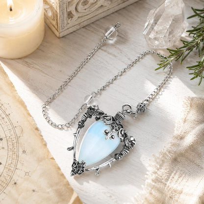 Opal-S water drop pendulum locket on a bright Pagan ritual altar