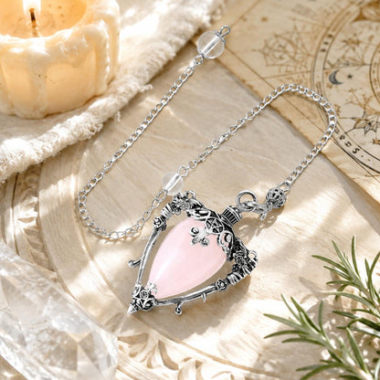 Rose Quartz-S water drop pendulum locket on a bright Pagan ritual altar