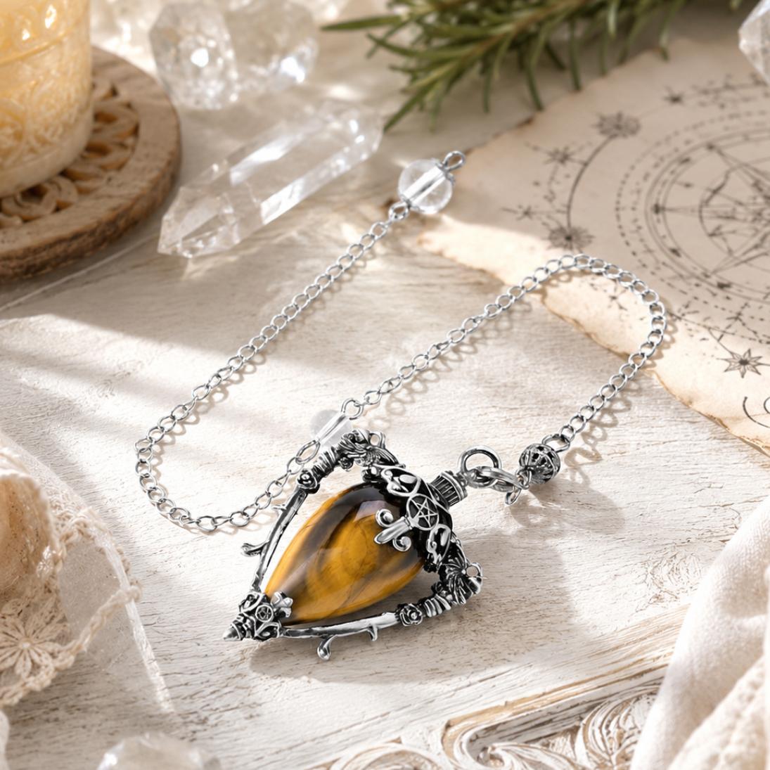 Tiger eye-S water drop pendulum locket on a bright Pagan ritual altar