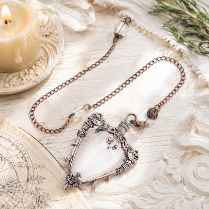 White Crystal water drop pendulum locket on a bright Pagan ritual altar