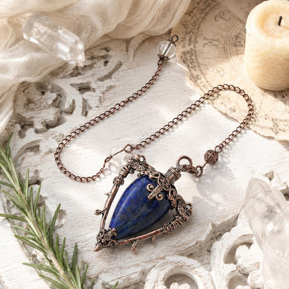Lapis water drop pendulum locket on a bright Pagan ritual altar