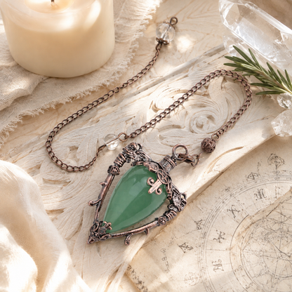 Aventurine water drop pendulum locket on a bright Pagan ritual altar