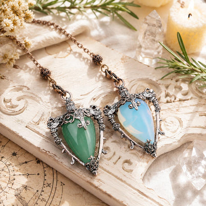 Aventurine and opal crystal pendulum lockets on a bright Pagan altar