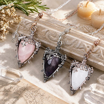 Water drop crystal pendulum locket collection on a bright Pagan ritual altar