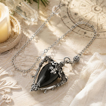 Obsidian-S water drop pendulum locket on a bright Pagan ritual altar
