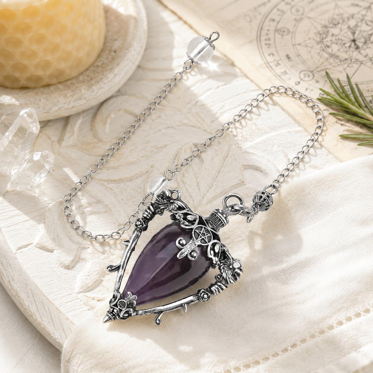 Amethyst-S water drop pendulum locket on a bright Pagan ritual altar
