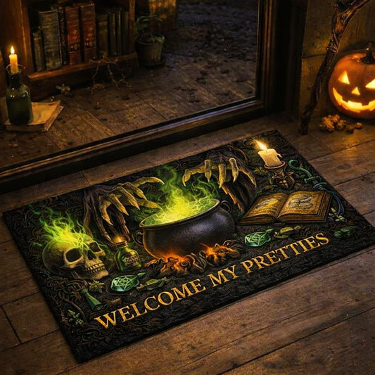 Black "Welcome My Pretties" doormat with green glowing cauldron, skull, witch hands, and spellbook.