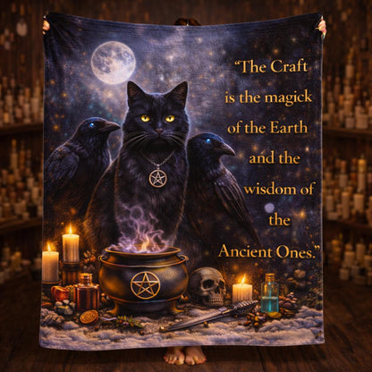 Wiccan black fleece blanket with a black cat, two ravens, a cauldron, candles, and a moon.