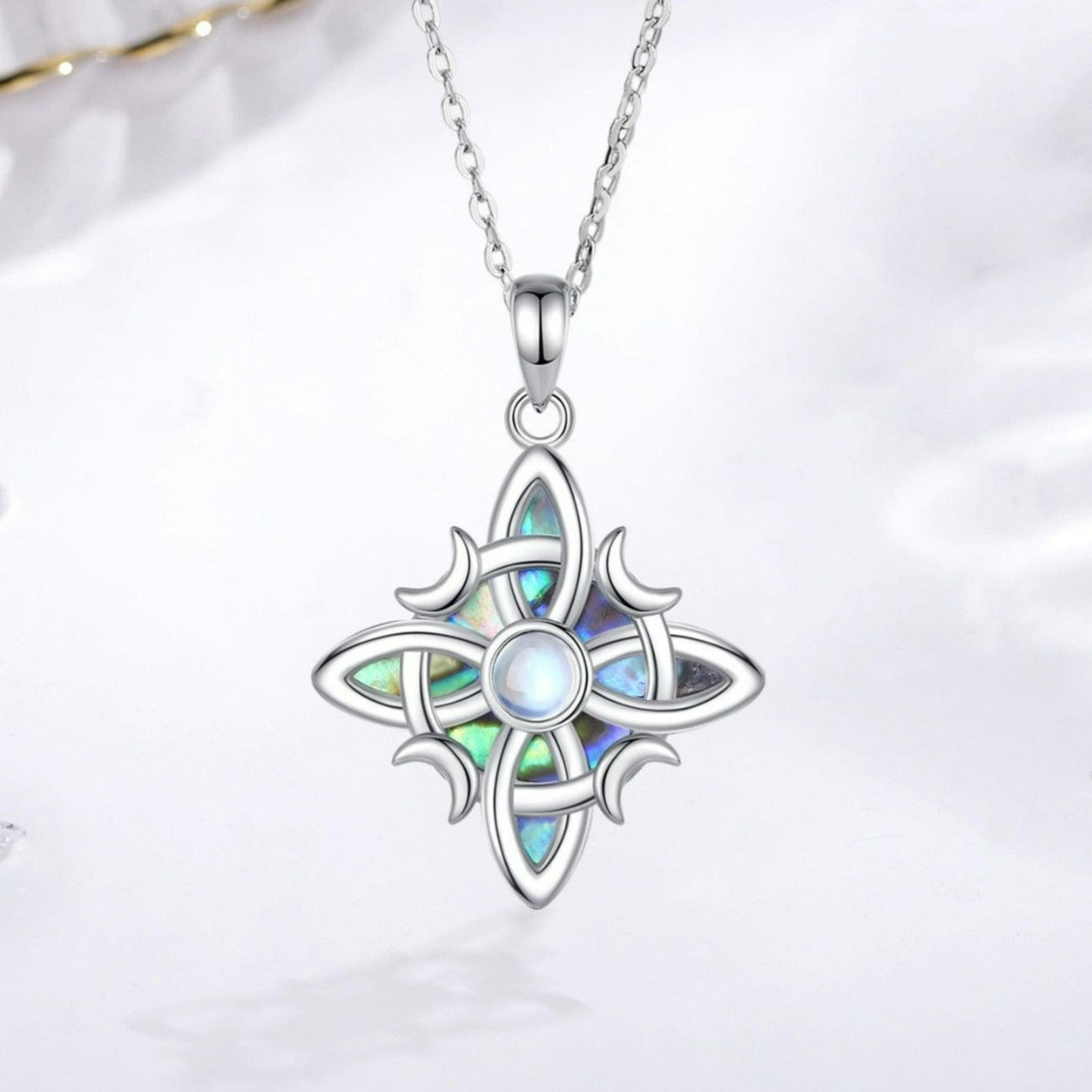 Sterling silver Witch Celtic Knot necklace with iridescent abalone inlay and a central moonstone, on an 18-inch chain.