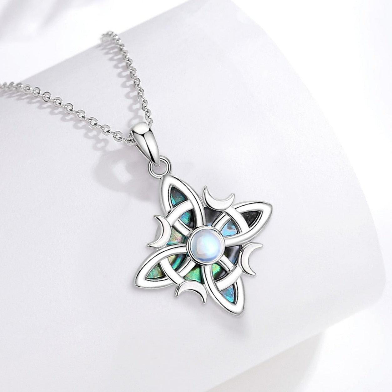 Sterling silver Witch Celtic Knot necklace with iridescent abalone inlay and a central moonstone, on a delicate chain.