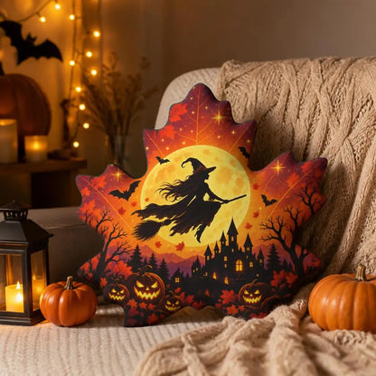 Styled room view: decorative plush pillow featuring maple leaf with witch, castle, moon and bat imagery