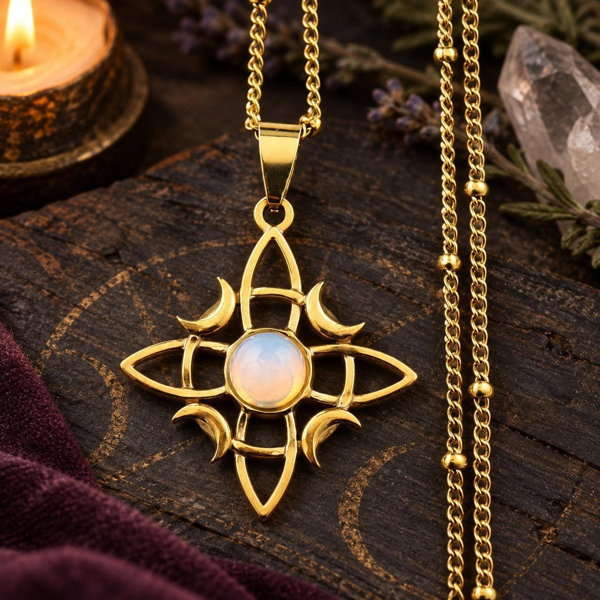 Gold-tone witch knot moon necklace with pale round stone center in a witchy altar setting