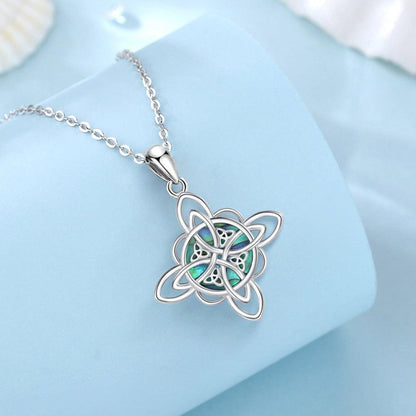 Sterling silver Witch Knot necklace with iridescent abalone shell, symbolizing protection and balance.