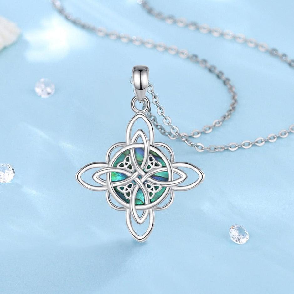 Sterling silver Witch Knot necklace with iridescent abalone shell, symbolizing protection and balance.