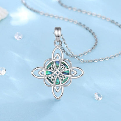 Sterling silver Witch Knot necklace with iridescent abalone shell, symbolizing protection and balance.