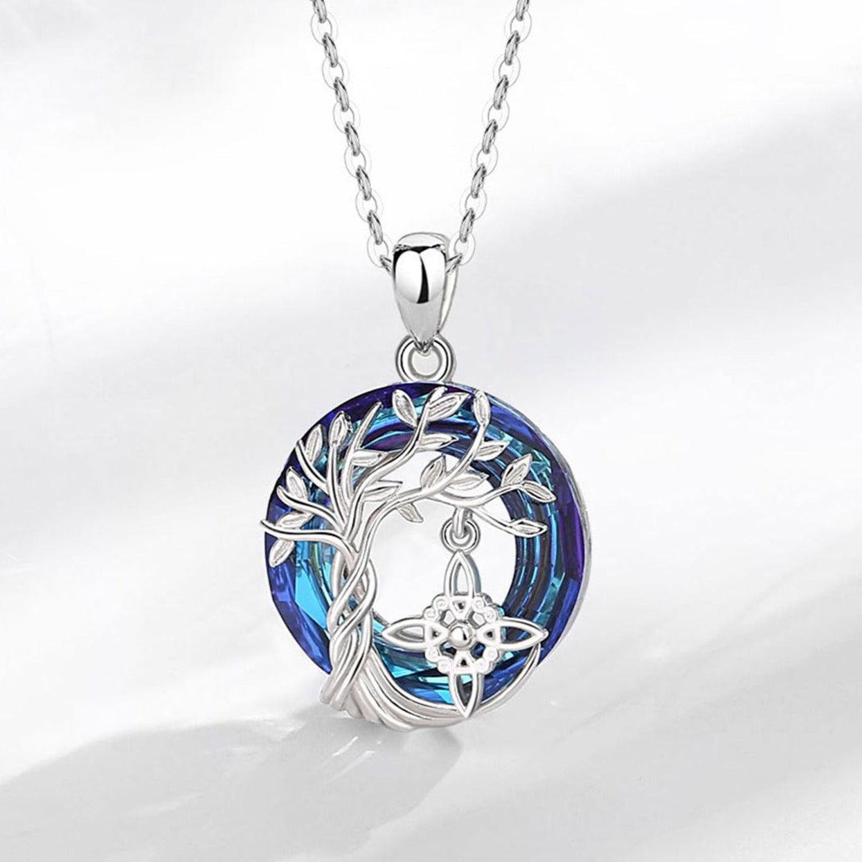 Sterling silver Witch Knot Tree of Life amulet necklace with a vibrant blue crystal and intricate pagan design.