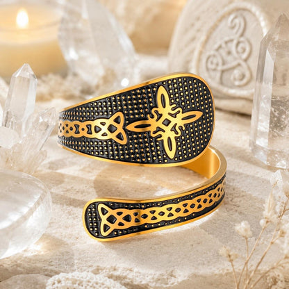 Gold Witch Knot open ring with Celtic endless knot detail on textured black band, surrounded by quartz crystals and a lit candle