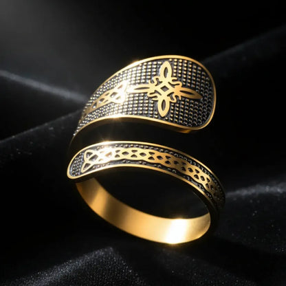 Gold Witch Knot open ring with Celtic trinity knot engraving, close-up on dark fabric with light reflection