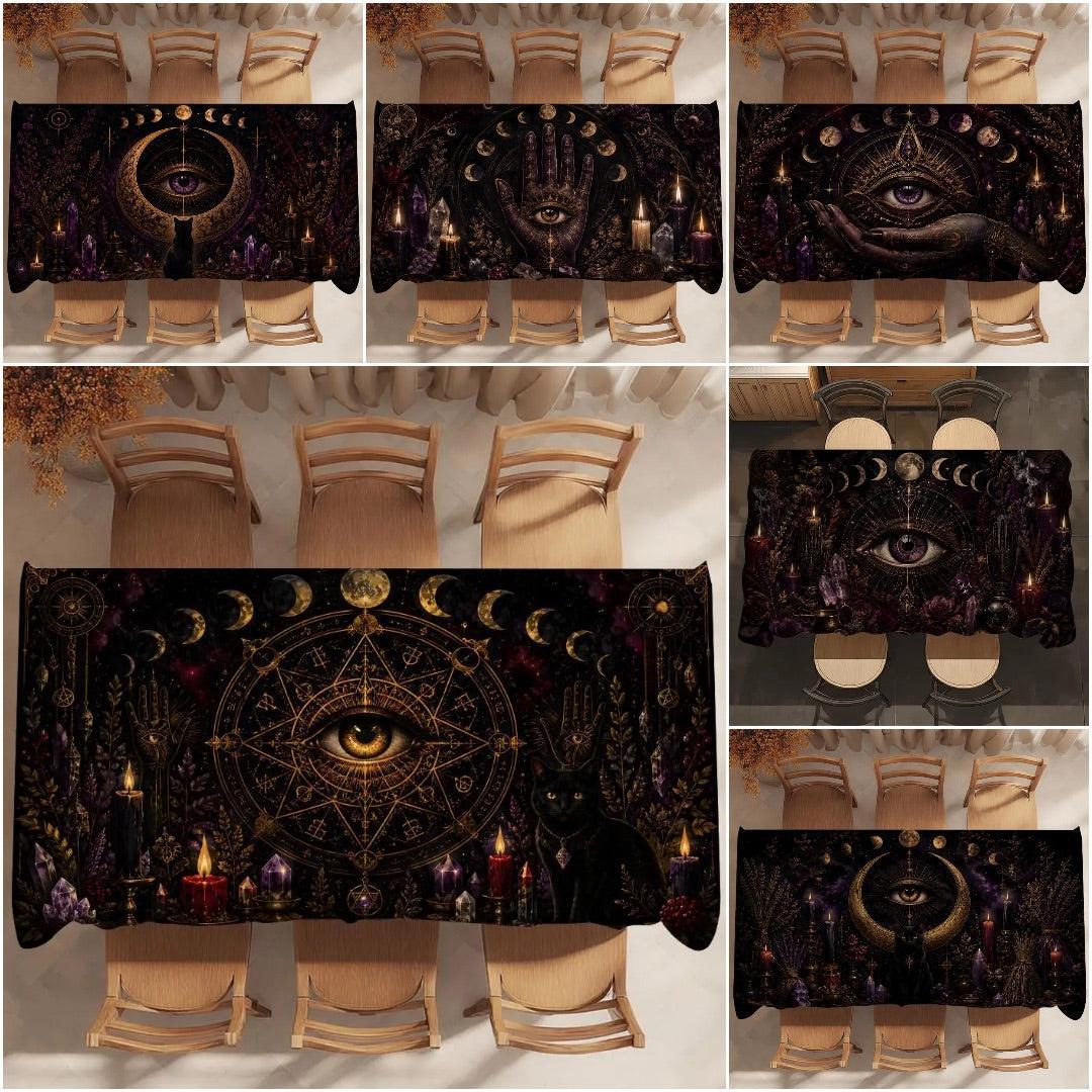 A collage showing a black tablecloth with a dark occult and mystical design, displayed on a dining table with chairs in multiple views. The design features a central eye within a pentagram, gold crescent moons, a black cat, candles, and purple and gold details.