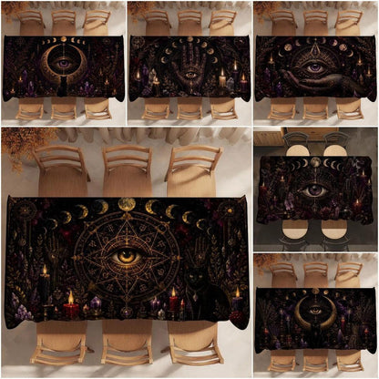 A collage showing a black tablecloth with a dark occult and mystical design, displayed on a dining table with chairs in multiple views. The design features a central eye within a pentagram, gold crescent moons, a black cat, candles, and purple and gold details.