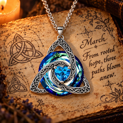 March Celtic Trinity Knot Birthstone Necklace on parchment — From rooted hope, three paths bloom anew.
