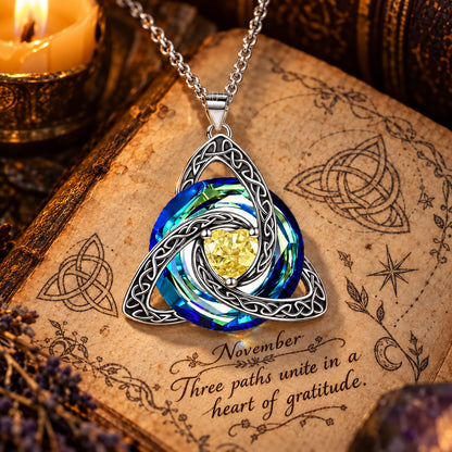 November Celtic Trinity Knot Birthstone Necklace on parchment — Three paths unite in a heart of gratitude.