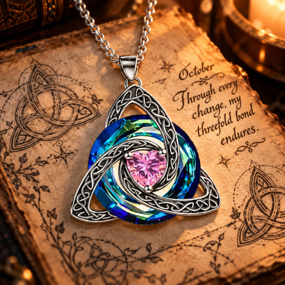 October Celtic Trinity Knot Birthstone Necklace on parchment — Through every change, my threefold bond endures.