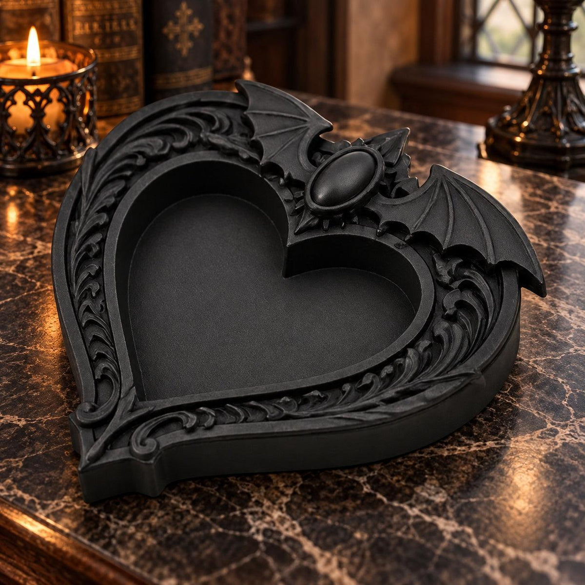 Angled view of the heart dish: Gothic Bat Wing Heart Jewelry Tray, featuring a heart-shaped center, outstretched bat wings and ornate raised scrollwork.