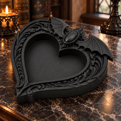 Angled view of the heart dish: Gothic Bat Wing Heart Jewelry Tray, featuring a heart-shaped center, outstretched bat wings and ornate raised scrollwork.