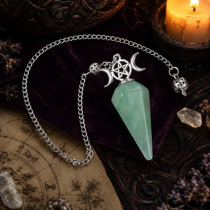 Green aventurine Triple Moon crystal pendulum on a Wiccan ritual altar