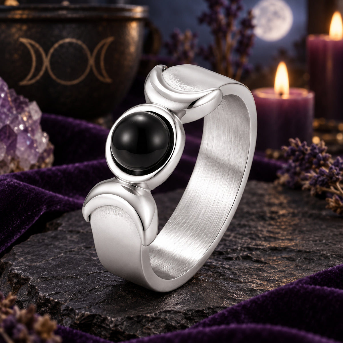 Silver Triple Moon Goddess ring with black onyx and crescent details on a dark Wiccan altar