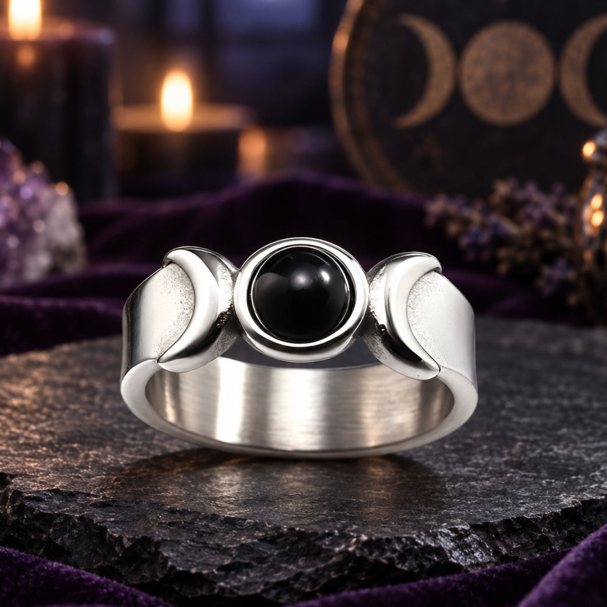 Silver Triple Moon Goddess ring with black onyx and crescent details on a dark Wiccan altar