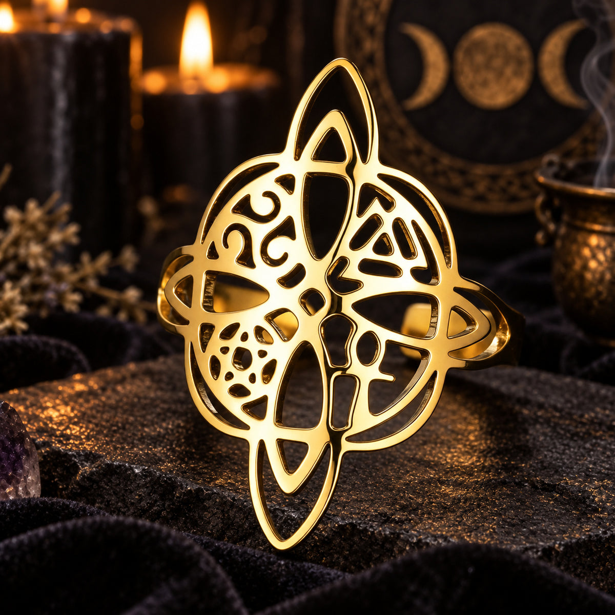 Gold witch knot pagan symbol ring on a dark ritual altar.
