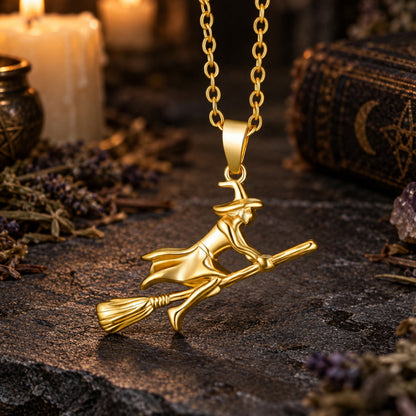 Gold Witch Riding Broom Necklace in a candlelit witchy altar scene, detailed polished pendant.