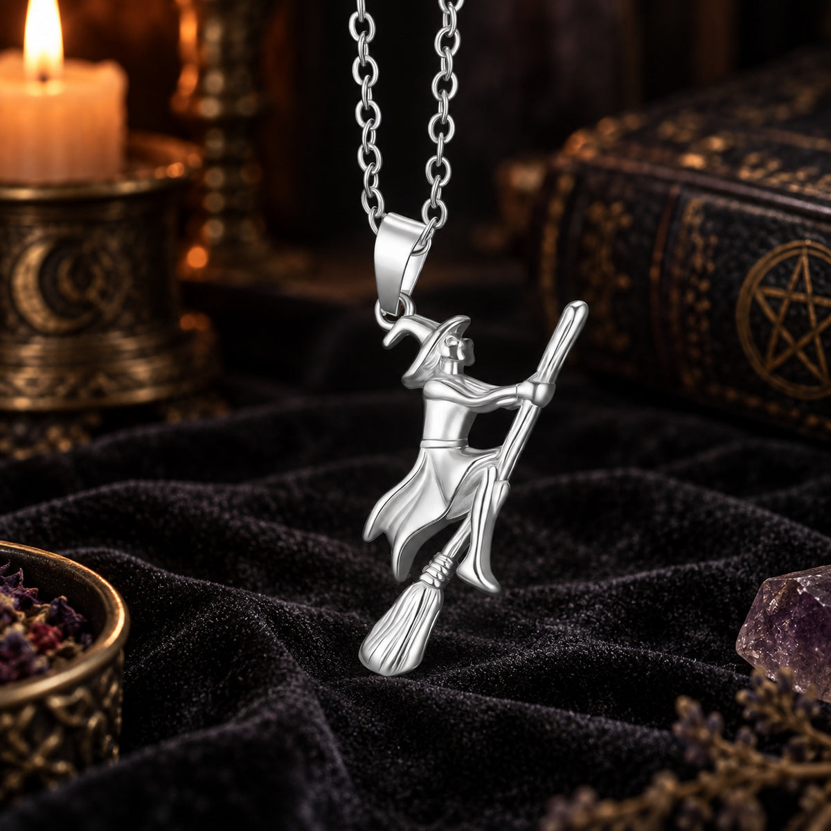 Silver Witch Riding Broom Necklace in a candlelit witchy altar scene, detailed polished pendant.