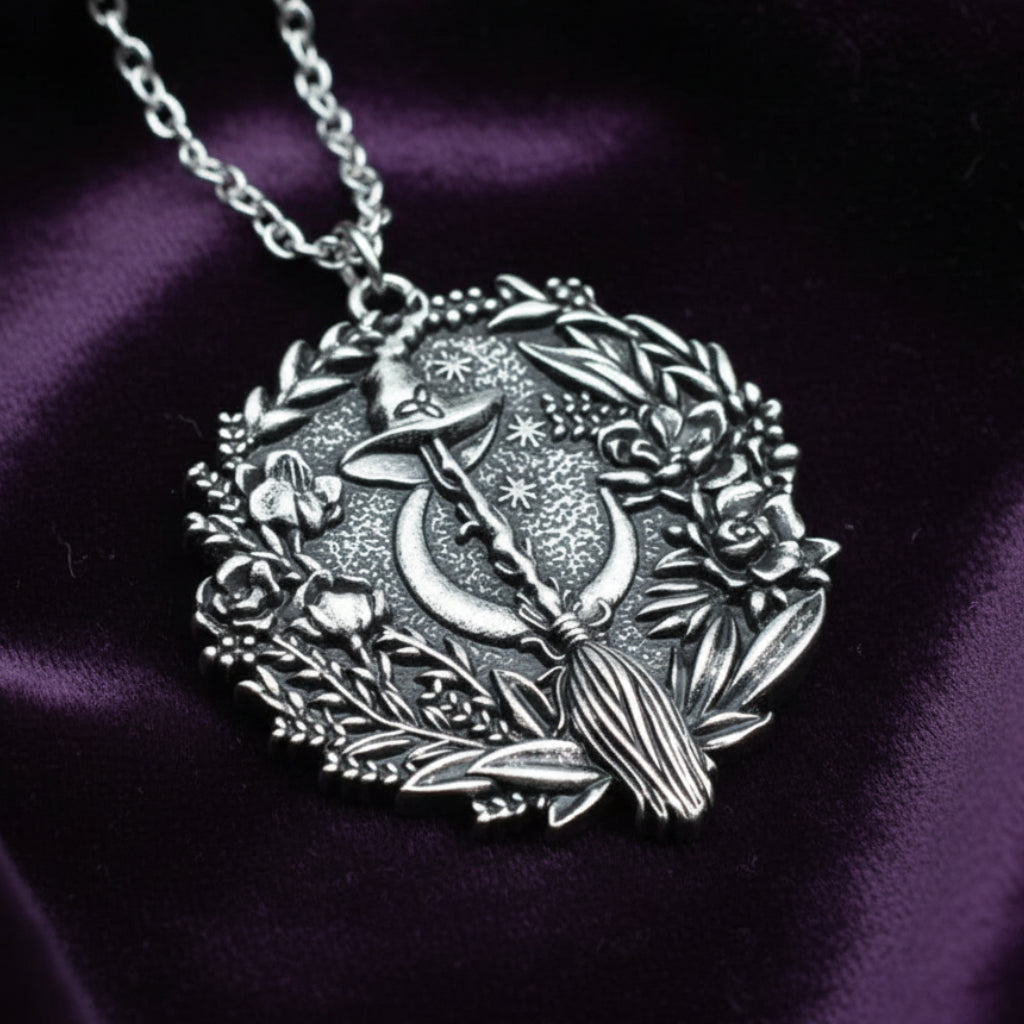 Silver plated Moon Hat Broom Witch Halloween necklace with floral wreath design.