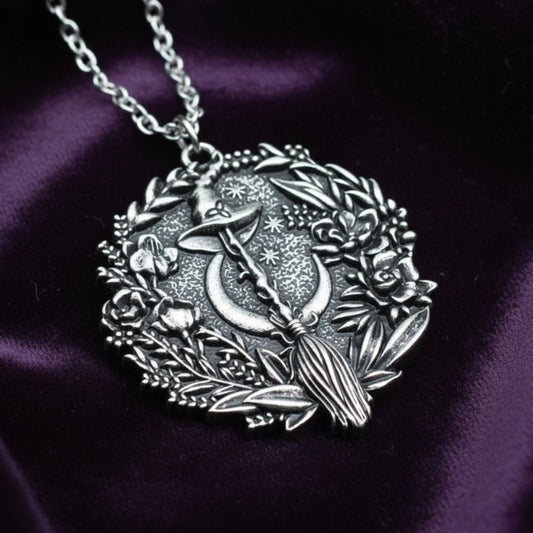Silver plated Moon Hat Broom Witch Halloween necklace with floral wreath design.